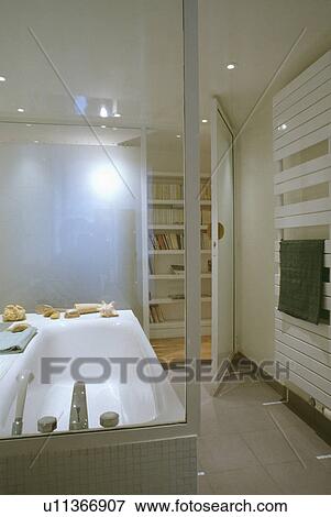 Modern white bathroom viewed through glass panel behind bath View Large Photo Image Stock Photo - Modern white bathroom viewed through glass panel behind bath. Fotosearch