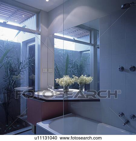 Stock Image - Modern white bathroom with white basin set into black marble shelf . Fotosearch