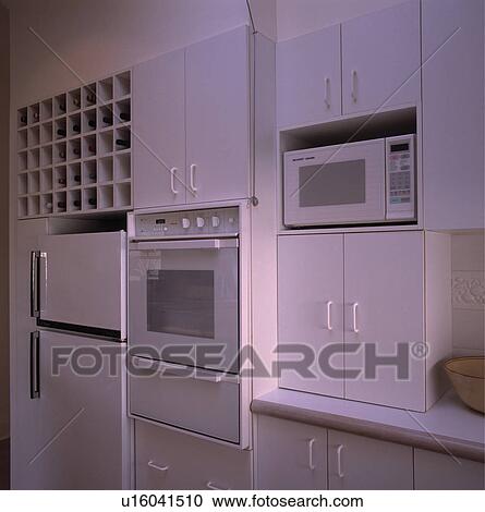 Modern white kitchen with fitted oven and microwave and fridge freezer View Large Photo Image Stock Image - Modern white kitchen with fitted oven and microwave and fridge freezer. Fotosearch