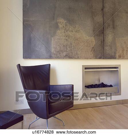 Montis black leather swivel armchair beside fireplace in modern livingroom with large abstract painting by Hannah Biggs View Large Photo Image Stock Photo - Montis black leather swivel armchair beside fireplace in modern livingroom with large abstract painting by Hannah Biggs. Fotosearch