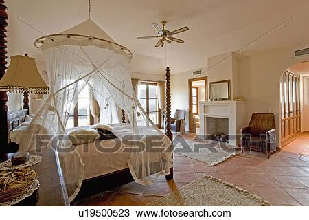 Mosquito net above bed in modern Spanish bedroom with traditional furniture View Large Photo Image Stock Image - Mosquito net above bed in modern Spanish bedroom with traditional furniture. Fotosearch