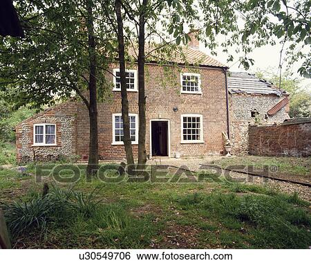 Newly renovated traditional Victorian old brick cottage with small trees in neglected front garden View Large Photo Image Stock Photograph - Newly renovated traditional Victorian old brick cottage with small trees in neglected front garden. Fotosearch