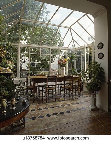 Old wood tables and chairs on terracotta tiled floor in conservatory dining room View Large Photo Image Picture - Old wood tables and chairs on terracotta tiled floor in conservatory dining room. Fotosearch