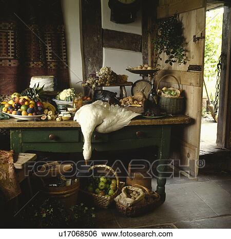 Old wooden table loaded with fruit and cheese and game in large country pantry View Large Photo Image Stock Photograph - Old wooden table loaded with fruit and cheese and game in large country pantry. Fotosearch