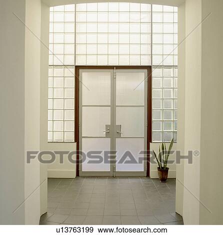 Opaque glass doors in glass brick wall in modern white architectural hall with grey floor tiles View Large Photo Image Stock Photo - Opaque glass doors in glass brick wall in modern white architectural hall with grey floor tiles. Fotosearch