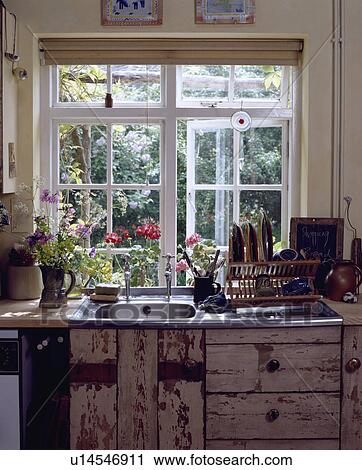 Open casement window above stainless steel sink in reclaimed rustic wood fitted cupboards View Large Photo Image Stock Image - Open casement window above stainless steel sink in reclaimed rustic wood fitted cupboards. Fotosearch