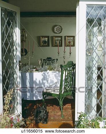 Open glass doors to diningroom with green chairs and white tablecloth with candelabra and glasses View Large Photo Image Stock Photography - Open glass doors to diningroom with green chairs and white tablecloth with candelabra and glasses. Fotosearch