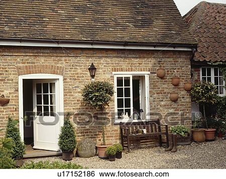 Open half-glazed white door in cottage extension with bench below window onto gravel courtyard View Large Photo Image Stock Photograph - Open half-glazed white door in cottage extension with bench below window onto gravel courtyard. Fotosearch
