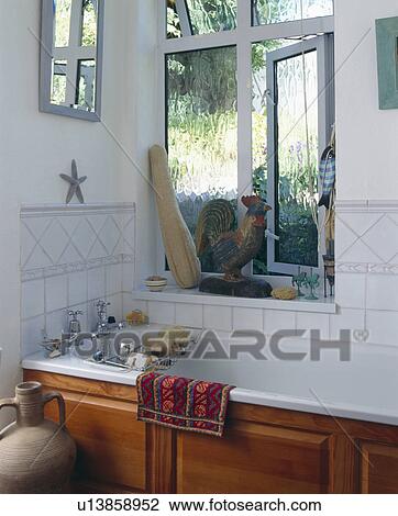 Open window with loofah on windowsill above wooden-panelled bath View Large Photo Image Stock Image - Open window with loofah on windowsill above wooden-panelled bath . Fotosearch
