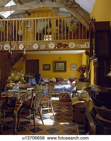 Stock Photo - Openplan yellow dining and living room in barn conversion. Fotosearch