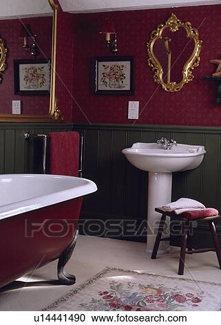 Ornate gilt mirror above white pedestal basin in red bathroom with green dado panelling and central rolltop bath View Large Photo Image Stock Image - Ornate gilt mirror above white pedestal basin in red bathroom with green dado panelling and central rolltop bath. Fotosearch