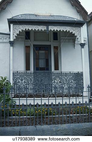 Stock Photo - Ornate wrought iron balcony and awning on Victorian townhouse. Fotosearch
