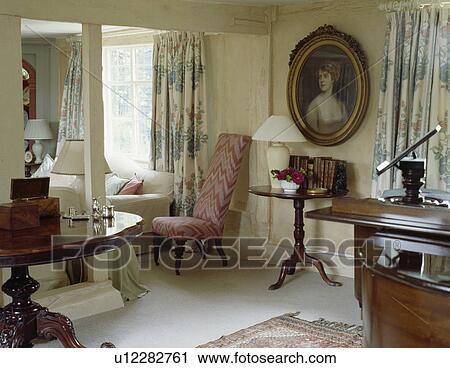 Stock Image - Oval picture in cream cottage living room. Fotosearch