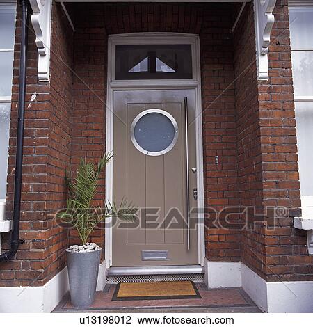 Palm in steel pot beside modern front door on traditional house View Large Photo Image Stock Image - Palm in steel pot beside modern front door on traditional house. Fotosearch