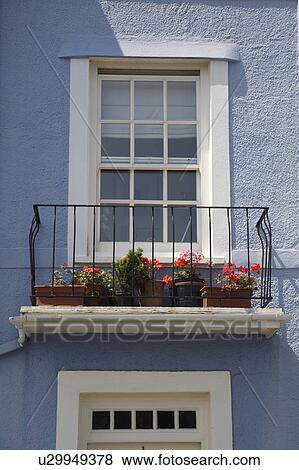 Pastel blue house with white sash windows and red geraniums on balcony View Large Photo Image Stock Photo - Pastel blue house with white sash windows and red geraniums on balcony. Fotosearch