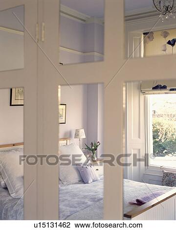 Pastel mauve bedroom reflected in mirror white cupboard doors View Large Photo Image Stock Image - Pastel mauve bedroom reflected in mirror white cupboard doors. Fotosearch