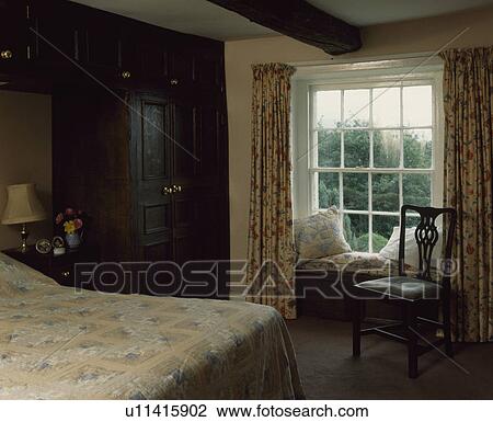 Patchwork quilt on bed in country bedroom with window seat and view of the garden through window View Large Photo Image Stock Image - Patchwork quilt on bed in country bedroom with window seat and view of the garden through window. Fotosearch