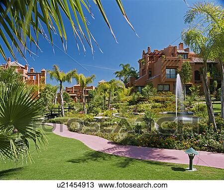 Path and pond with fountain in garden of Spanish apartments View Large Photo Image Stock Image - Path and pond with fountain in garden of Spanish apartments. Fotosearch