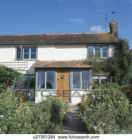 Path through front garden to white cottage with porch extension View Large Photo Image Picture - Path through front garden to white cottage with porch extension . Fotosearch