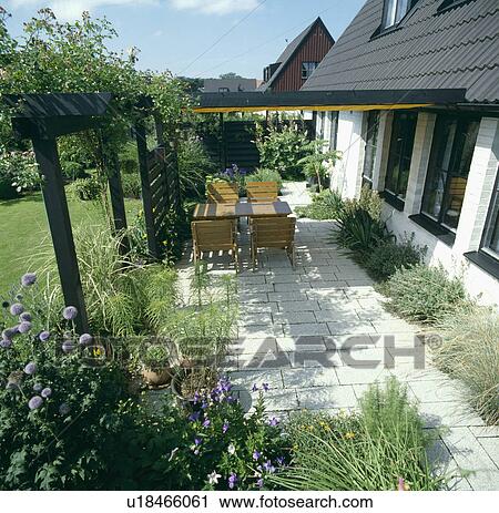 Stock Image -  Patio below pergola in country garden in summer. Fotosearch