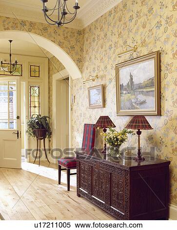 Patterned cream floral wallpaper in country hall with wooden flooring and picture above carved wooden chest View Large Photo Image Stock Photography - Patterned cream floral wallpaper in country hall with wooden flooring and picture above carved wooden chest. Fotosearch