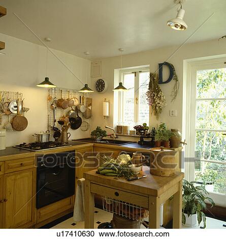 Pendant lighting in small kitchen with fitted wooden cupboards and butcher's block View Large Photo Image Stock Image - Pendant lighting in small kitchen with fitted wooden cupboards and butcher's block. Fotosearch