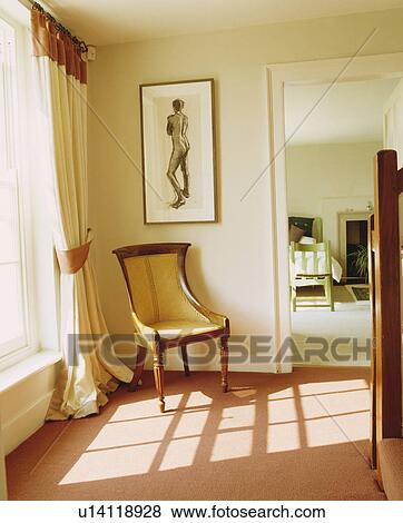 Picture above antique chair in corner of cream hall with peach carpet and cream curtain with brown border View Large Photo Image Stock Photo - Picture above antique chair in corner of cream hall with peach carpet and cream curtain with brown border. Fotosearch
