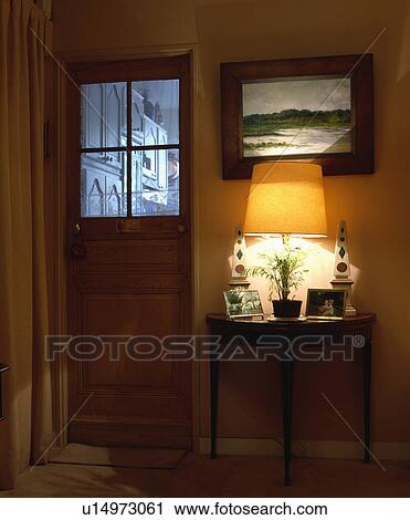 Picture above lighted lamp above small table in hall with window in wooden door View Large Photo Image Stock Image - Picture above lighted lamp above small table in hall with window in wooden door. Fotosearch