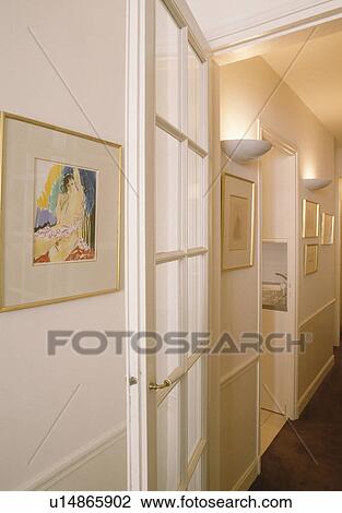 Picture beside glazed door in narrow white hall with uplighting View Large Photo Image Stock Image - Picture beside glazed door in narrow white hall with uplighting. Fotosearch