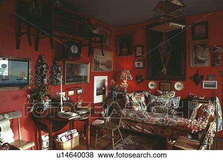 Pictures and small chairs on wall in traditional red living room View Large Photo Image Stock Photo - Pictures and small chairs on wall in traditional red living room. Fotosearch