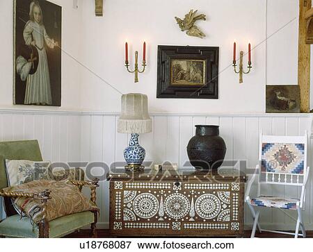 Stock Photo - Pictures on wall in above antique inlaid chest. Fotosearch