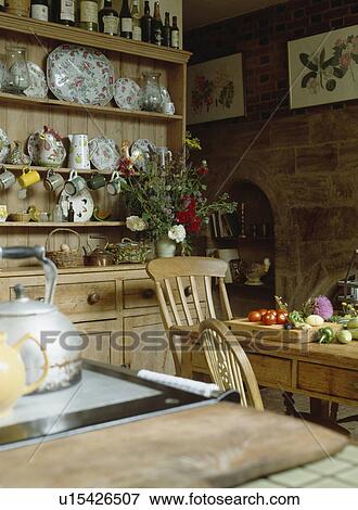 Pine dresser in country kitchen with vegetables on chopping board on pine table View Large Photo Image Stock Photo - Pine dresser in country kitchen with vegetables on chopping board on pine table . Fotosearch