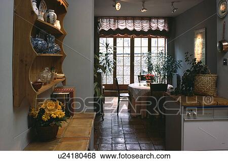 Pine shelves and terracotta tiled floor in sixties kitchen dining room View Large Photo Image Stock Photo - Pine shelves and terracotta tiled floor in sixties kitchen dining room. Fotosearch