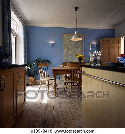 Pine table and chairs and wooden flooring in modern blue kitchen View Large Photo Image Stock Photo - Pine table and chairs and wooden flooring in modern blue kitchen. Fotosearch