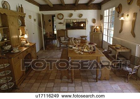 Pine table and chairs in country dining room with pine dresser and terracotta tiled floor View Large Photo Image Stock Photo - Pine table and chairs in country dining room with pine dresser and terracotta tiled floor. Fotosearch