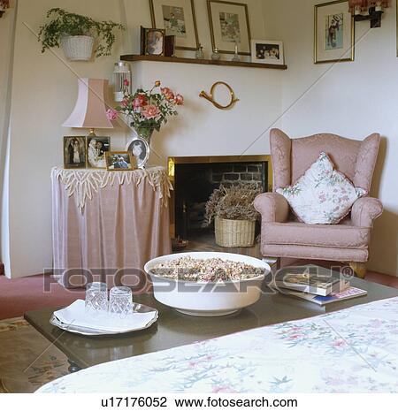 Pink armchair and table with pink cloth beside fireplace in country bedroom View Large Photo Image Stock Image - Pink armchair and table with pink cloth beside fireplace in country bedroom. Fotosearch