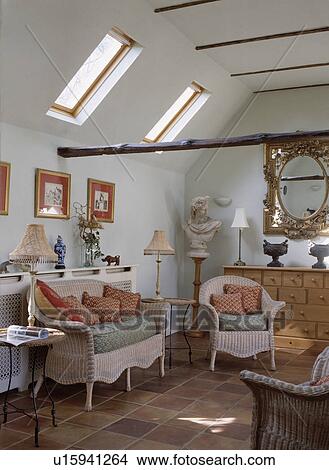 Picture - Pink wicker sofa and armchair in white loft conversion living room. Fotosearch