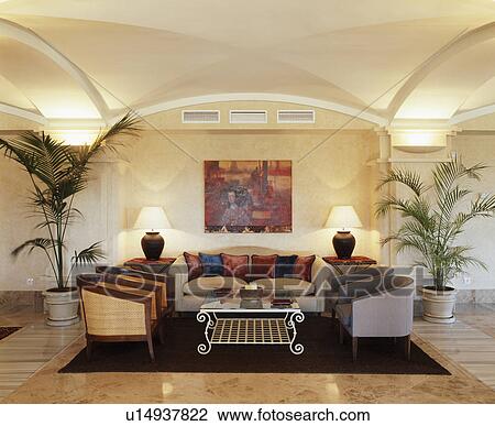 Potted palm trees in basement living room with lighted lamps View Large Photo Image Stock Image - Potted palm trees in basement living room with lighted lamps. Fotosearch