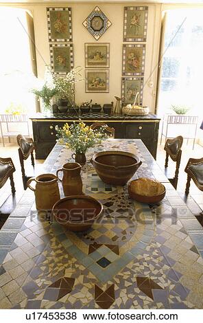Pottery jugs and bowls on mosaic table in traditional dining room View Large Photo Image Stock Photo - Pottery jugs and bowls on mosaic table in traditional dining room. Fotosearch