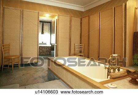 Rattan panelled walls in oriental-style bathroom with rattan bath panel and door open to bedroom View Large Photo Image Stock Image - Rattan panelled walls in oriental-style bathroom with rattan bath panel and door open to bedroom. Fotosearch