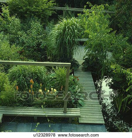 Stock Photo - Rectangular pond and decking in country garden in summer. Fotosearch