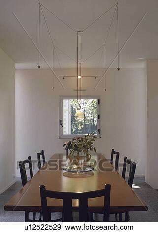 Rectangular table below suspended lighting in modern white dining room View Large Photo Image Stock Photo - Rectangular table below suspended lighting in modern white dining room. Fotosearch