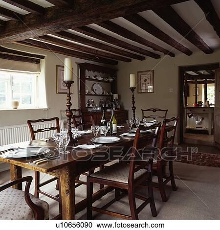 Rectangular wooden table and antique chairs in country dining room with beamed ceiling View Large Photo Image Stock Image - Rectangular wooden table and antique chairs in country dining room with beamed ceiling. Fotosearch