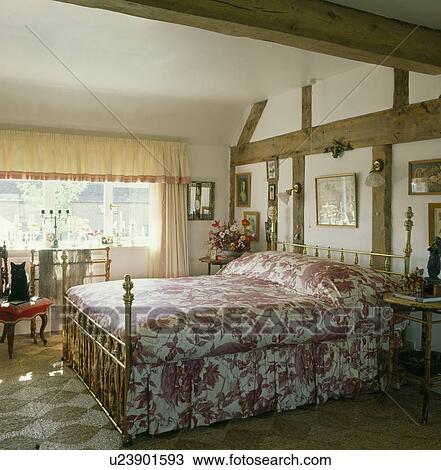 Red and white chintz bedcover on brass bed in country bedroom with beams and rush matting View Large Photo Image Stock Image - Red and white chintz bedcover on brass bed in country bedroom with beams and rush matting. Fotosearch