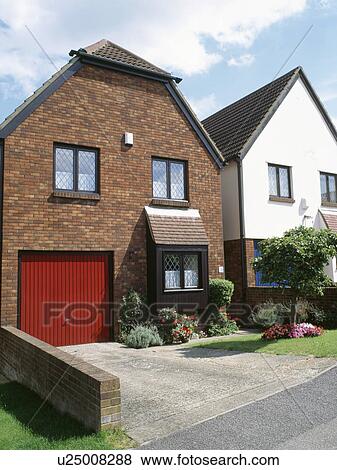 Stock Photo - Red garage doors on small detached newbuild house. Fotosearch