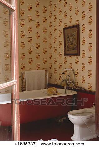 Red shield pattern stencilled onto walls of bathroom with red clawfoot bath and white bidet View Large Photo Image Stock Image - Red shield pattern stencilled onto walls of bathroom with red clawfoot bath and white bidet . Fotosearch