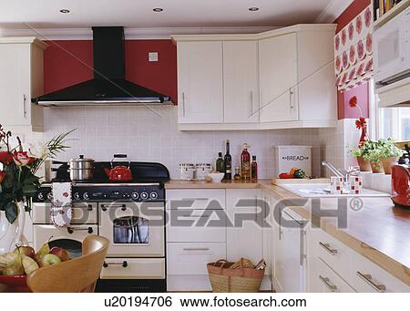 Red wall above cream range oven in white cottage kitchen with beech worktops View Large Photo Image Stock Photograph - Red wall above cream range oven in white cottage kitchen with beech worktops. Fotosearch