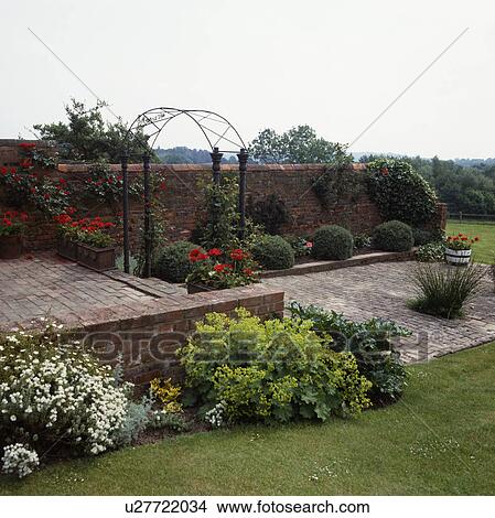 Rose arch and paved patio in country garden in summer View Large Photo Image Picture - Rose arch and paved patio in country garden in summer. Fotosearch
