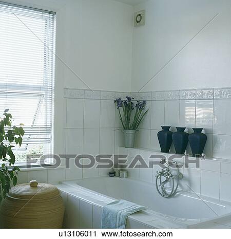 Row of pots on tiled shelf above bath in white bathroom with tiled walls to dado height View Large Photo Image Stock Image - Row of pots on tiled shelf above bath in white bathroom with tiled walls to dado height. Fotosearch