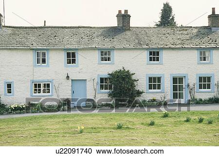 Stock Image - Row of traditional white terraced country cottages with blue paintwork. Fotosearch